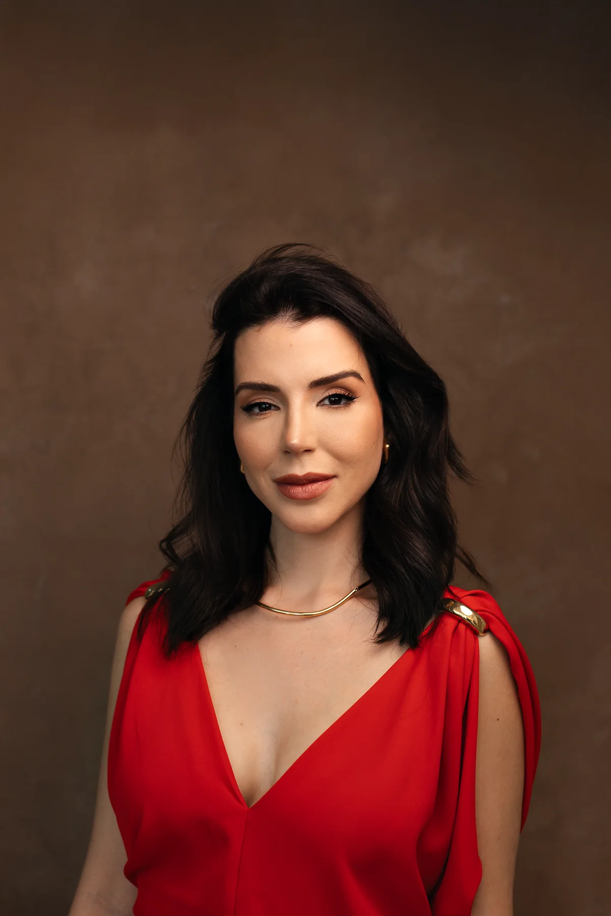 Dra. Amanda Bissoli usando um vestido vermelho em retrato editorial